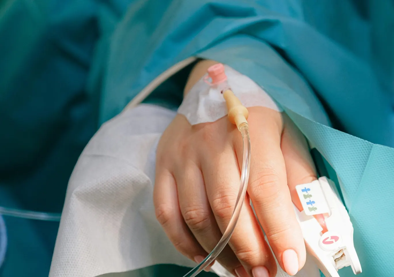 Odtrucie alkoholowe Chełm: dłoń z wenflonem i pulsoksymetrem pod nadzorem