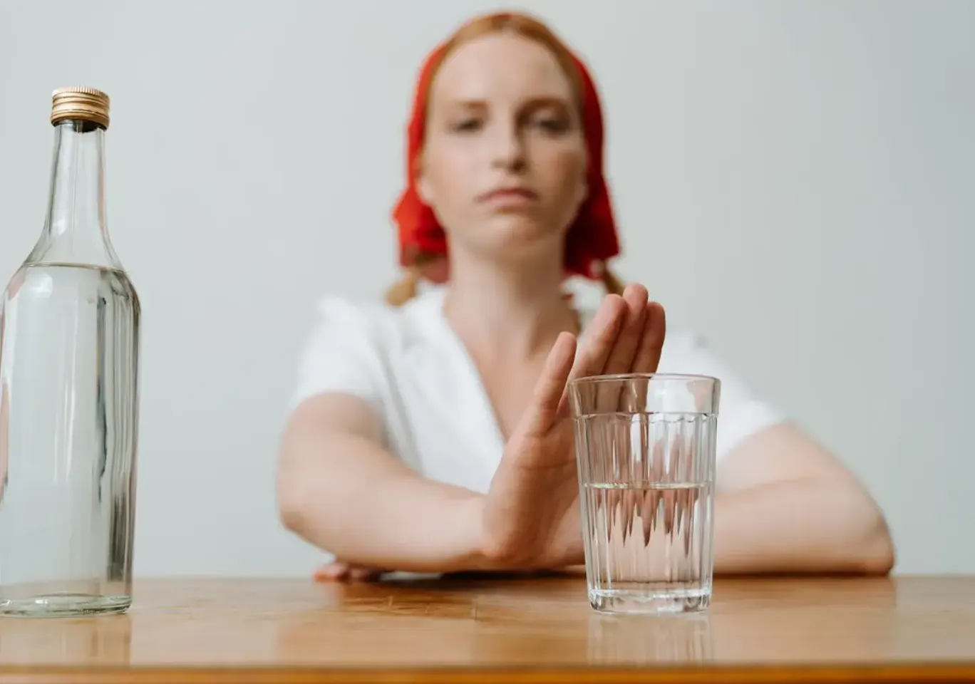 Leczenie alkoholizmu Chełm: kobieta odsuwa butelkę i sięga po wodę